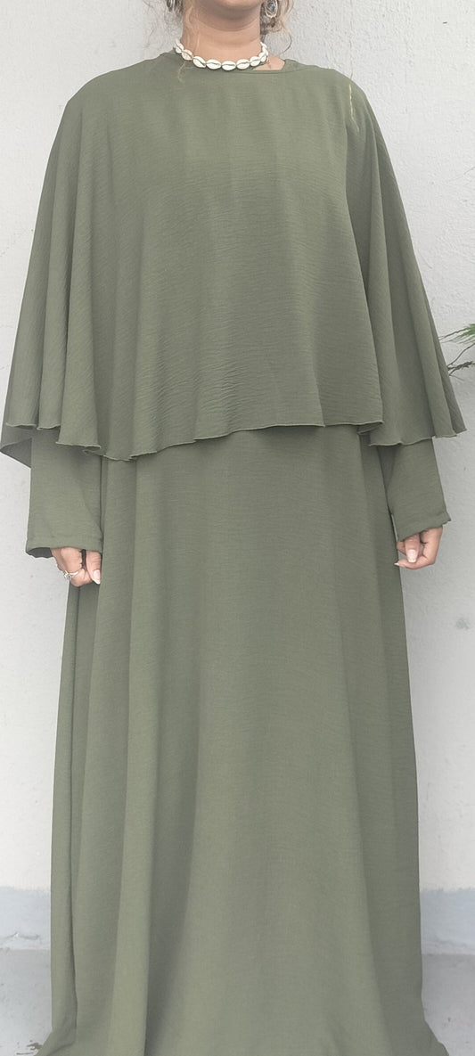 Person wearing a green two-piece outfit against a white background